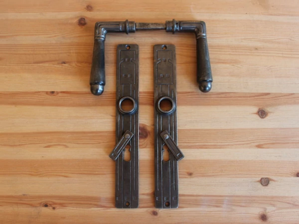 Geometrischer Jugendstil Türbeschlag aus patiniertem Gusseisen mit geradlinigen Reliefstrukturen auf Langschild