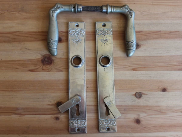 Vernickelte Jugendstil Türklinke mit floralem Ornamentband auf Messing-Langschild